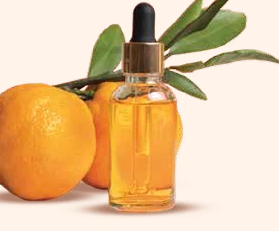 Cold-pressed citrus peel oil in a glass dropper bottle beside fresh citrus